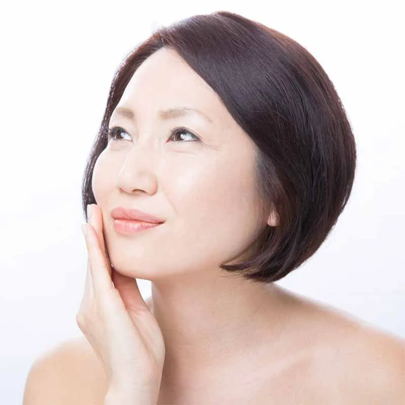 Woman with a clear complexion, hand on her face