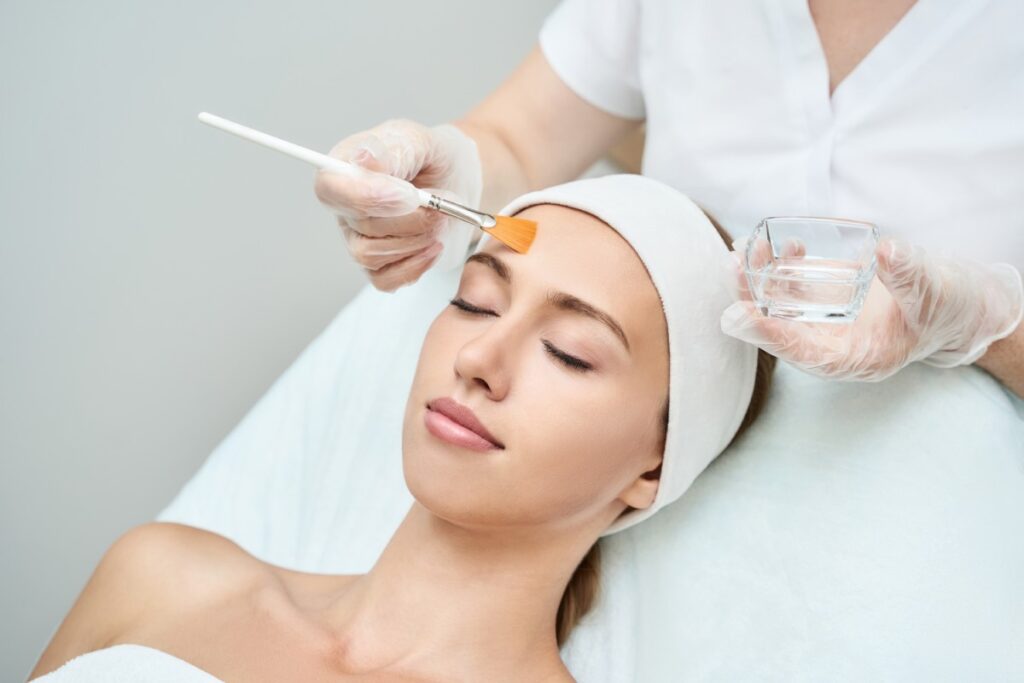 Treatment provider applying chemical peel treatment to clients face