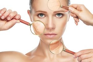 woman with magnifying glass over her skin's imperfections and is seeking a medical spa for Microdermabrasion treatment