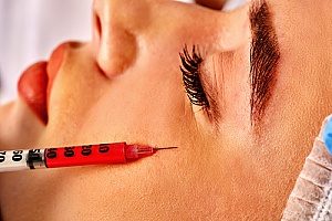 a woman receiving under eye filler at the base of her left eye to treat dark circles