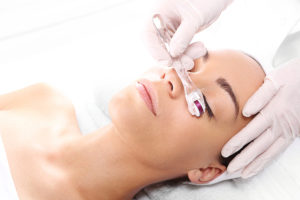 a woman having a microneedling treatment around her eyes