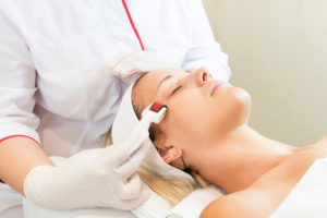 a woman getting a microneedling treatment by a trained esthetician