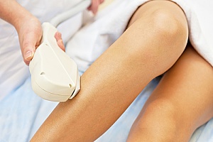 a woman receiving treatment at a medical spa to remove hair in her legs
