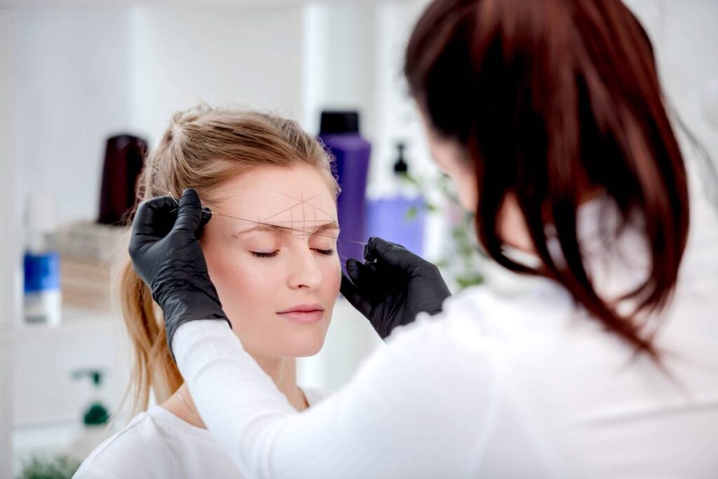 Cosmetic tattoo artist mapping eyebrows